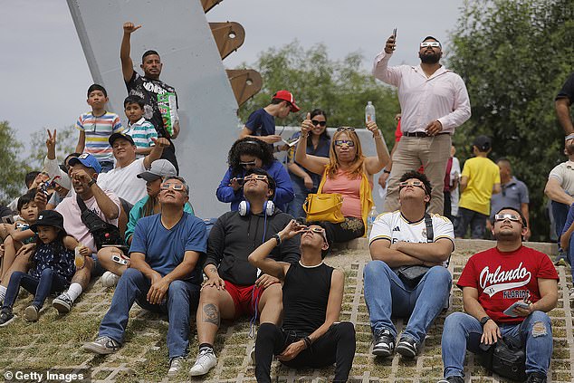 Residents of Torreón, a city in the state of Coahuila, northeastern Mexico, gather on Monday to observe the total solar eclipse
