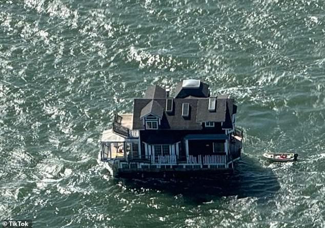 The U.S. Coast Guard oversaw the move of the shingle boathouse, which was towed by a smaller boat as it glided across the bay.