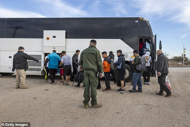 Immigrants board a US Customs and Border Protection bus after crossing the US-Mexico border