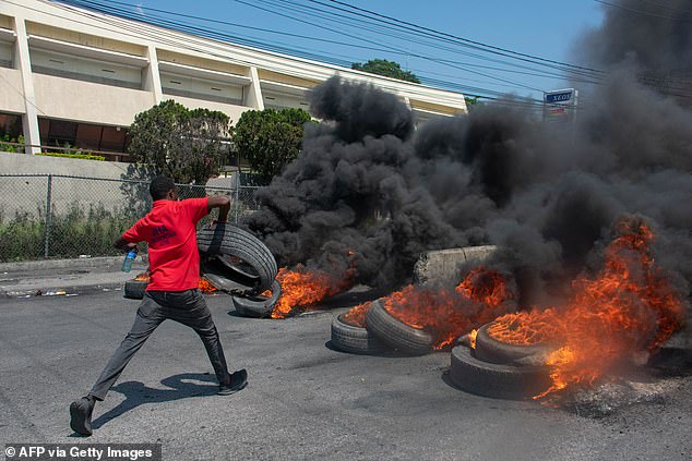 A protester burns tires during a demonstration following the resignation of Prime Minister Ariel Henry, in Port-au-Prince, Haiti, on March 12, 2024.