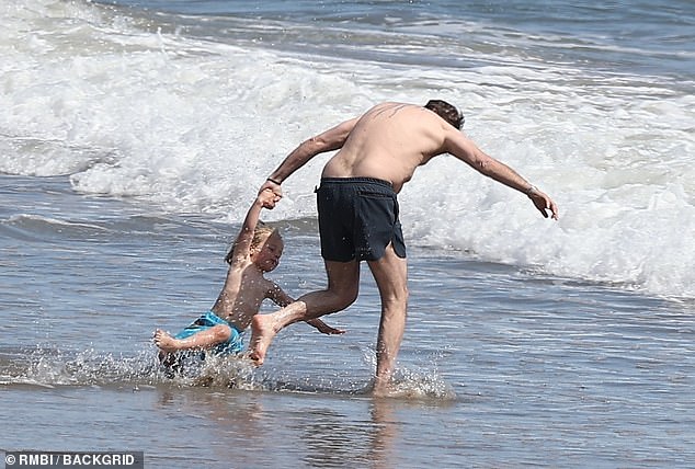 Hunter could be seen urging his son into the waves. He shares four-year-old Beau with his wife Melissa Cohen