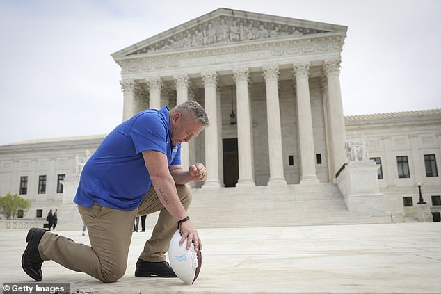 Former Bremerton High School assistant football coach Joe Kennedy kneels in front of the United States Supreme Court after his legal case.