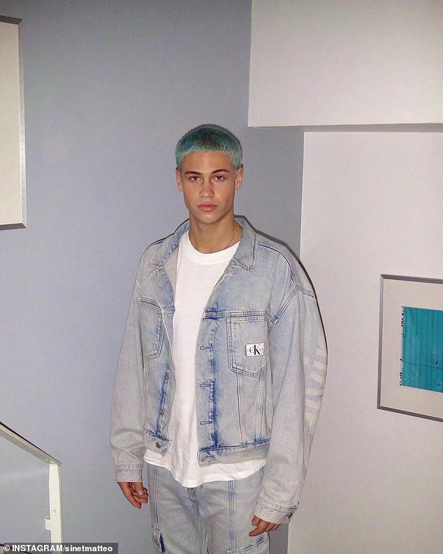 The light blue-haired model wore a black sweatshirt with matching sweatpants and carried a camouflage backpack while dancing.