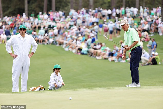 He watches his grandfather, who won the green jacket in 1984 and 1995, on the grass.