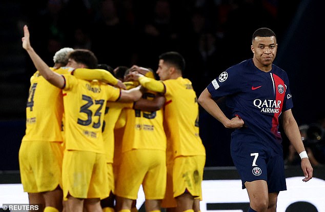 Kylian Mbappé looks dejected as Barcelona celebrates their third goal of the night.