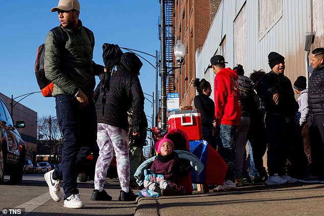Yanis Vasques, 3, center, sits next to her mother Verónica Vasques, 23, left, both from Venezuela, as she sells food outside a migrant shelter on the Lower West Side on Feb. 15 in Chicago.