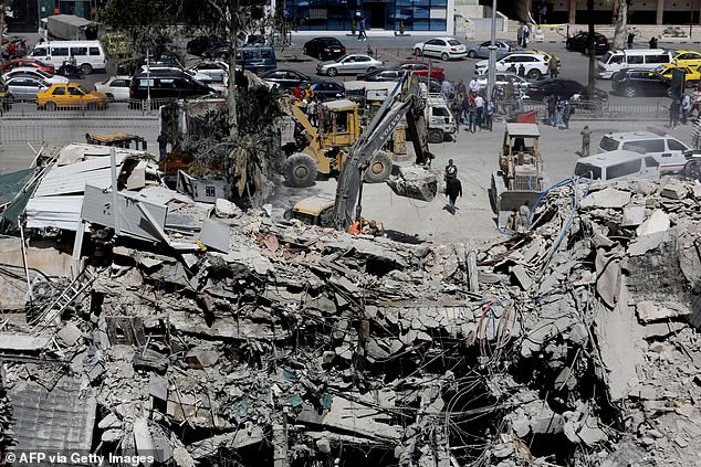Rescuers search through the rubble of a building attached to the Iranian embassy a day after an airstrike in Damascus.