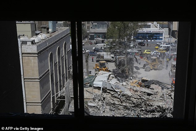 Rescuers search through the rubble of a building attached to the Iranian embassy a day after an airstrike in Damascus on April 2, 2024.