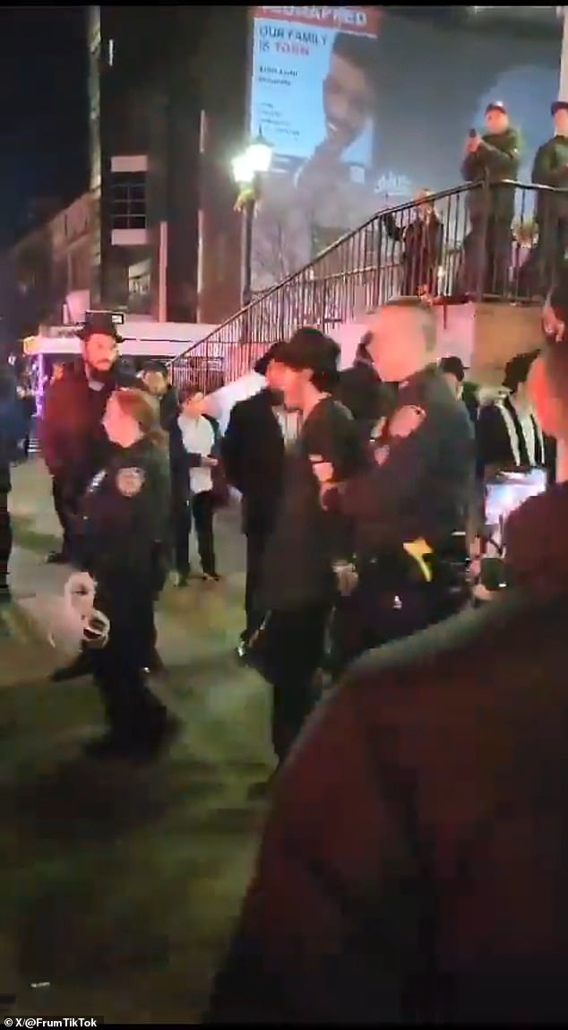 The photo shows young men being arrested, handcuffed and taken away by the NYPD.