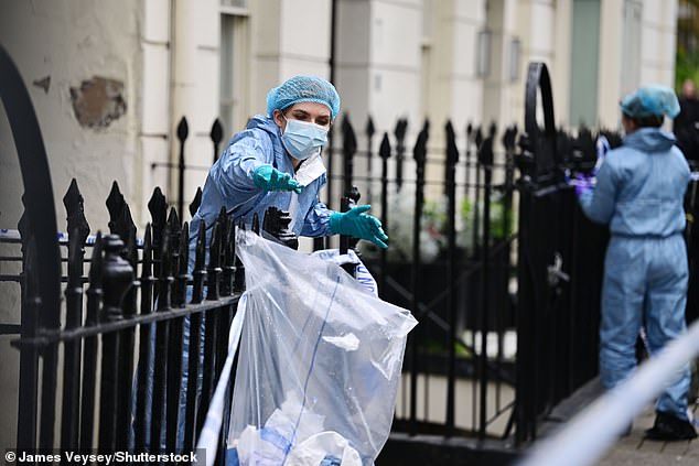 Forensic officers dump items in a bag outside the house in London's upmarket Bayswater district, within the Borough of Westminster.