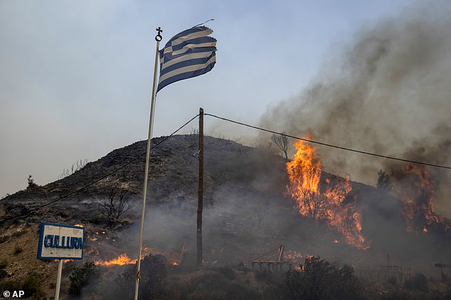 Flames burn a hill on the island of Rhodes in the Aegean Sea