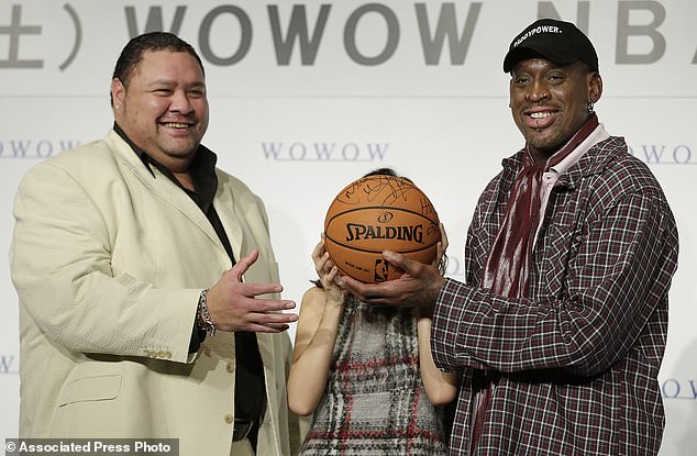 Former NBA basketball player Dennis Rodman (right), former sumo grand champion Akebono (left) and Japanese actress Maomi Yuki pose for photographers during a press conference to promote a television show in Tokyo, 25 October 2013.