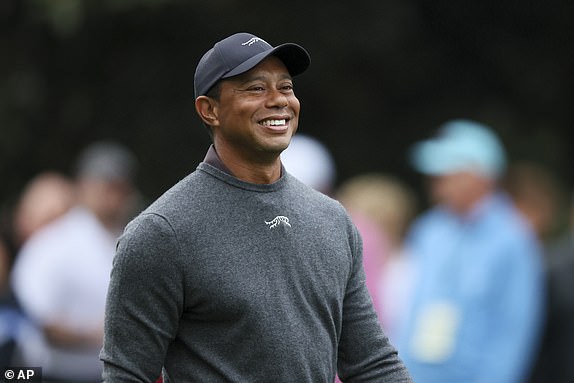 Tiger Woods reacts as he talks to other golfers as they walk down the second fairway after his tee shots during a practice round for the Masters golf tournament at Augusta National Golf Club in Augusta, Georgia, Tuesday, April 9, 2024. (Jason Getz /Atlanta Journal-Constitution via AP)