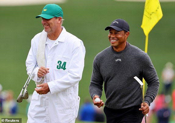 Golf - The Masters - Augusta National Golf Club, Augusta, Georgia, U.S. - April 9, 2024 Tiger Woods of the U.S. and his caddy on the green on the 9th hole during a practice round REUTERS/Mike Blake