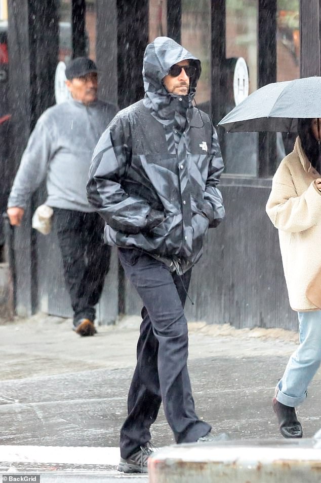 The 49-year-old actor covered up in a gray printed rain jacket from North Face, adding jeans and sunglasses.