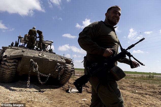 Israeli soldiers prepare their equipment and armored personnel carrier before entering the Gaza Strip on April 10, 2024.