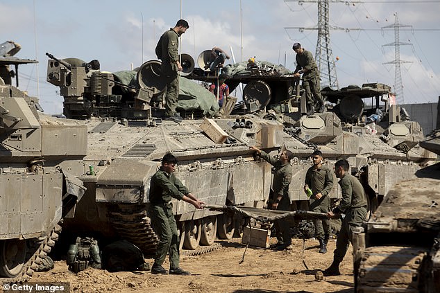 Israeli soldiers prepare their equipment and armored personnel carriers before entering the Gaza Strip on April 10, 2024.