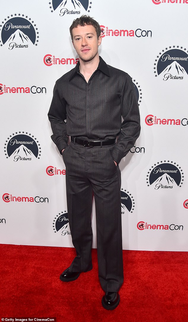 Quinn wore a dark gray-on-gray look that consisted of a button-down shirt and pants.