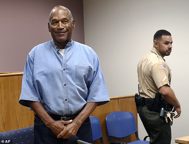 Simpson seen smiling as he enters his parole hearing in 2008