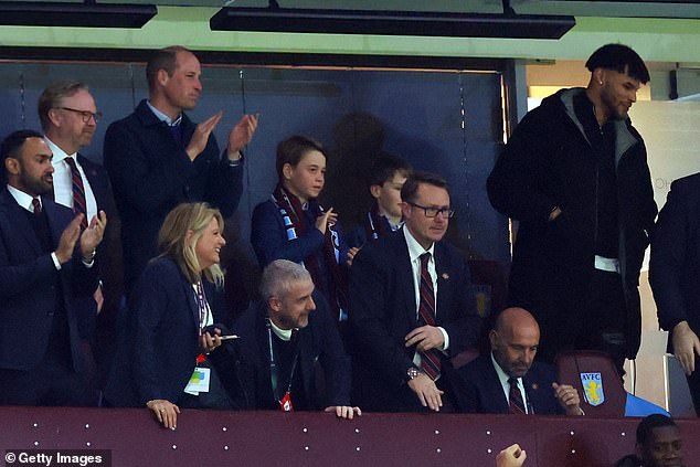 Prince William and Prince George of Wales watch the match alongside Villa center Tyrone Mings (right)