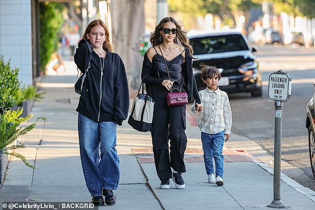 Her daughter showed off her youthful style in a black zip-up hoodie, oversized jeans, and chunky black boots.