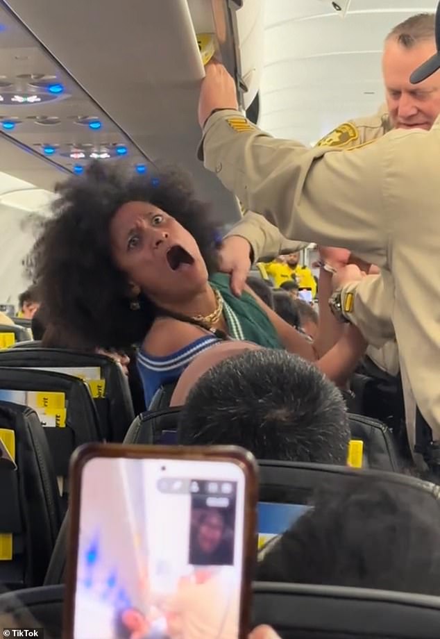 A woman aboard a Spirit Airlines flight out of Las Vegas had a mad meltdown on board and screamed the n-word as police officers removed her from the plane.