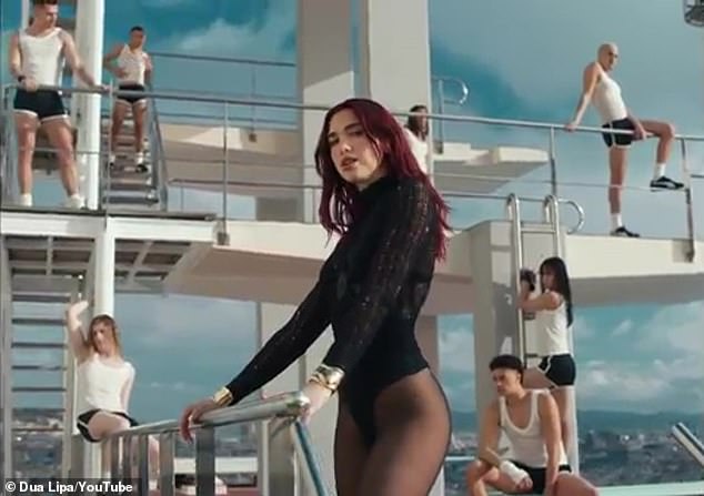 The video begins with the singer walking on the large platform near the pool and supervising while the dancers in shorts do their exercise routine.