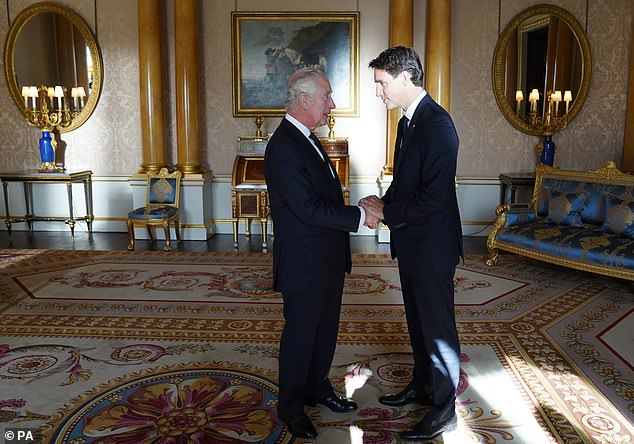 King Charles III shakes hands with Canadian Prime Minister Justin Trudeau at Buckingham Palace on September 17, 2022.