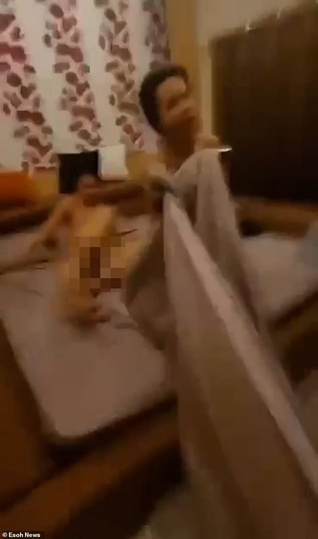 Bursting into the couple, the 64-year-old is seen bursting into the bedroom and removing the sheets to reveal his naked Democratic Party wife, Prapaporn Choeiwadkoh, 45, next to naked monk Phra Maha.
