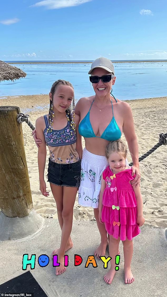 The radio queen looked stunning in the skimpy blue swimsuit as she posed on the beach alongside her daughters, Beatrix 'Trixie' Belle, 11, and Daisy Belle, four.