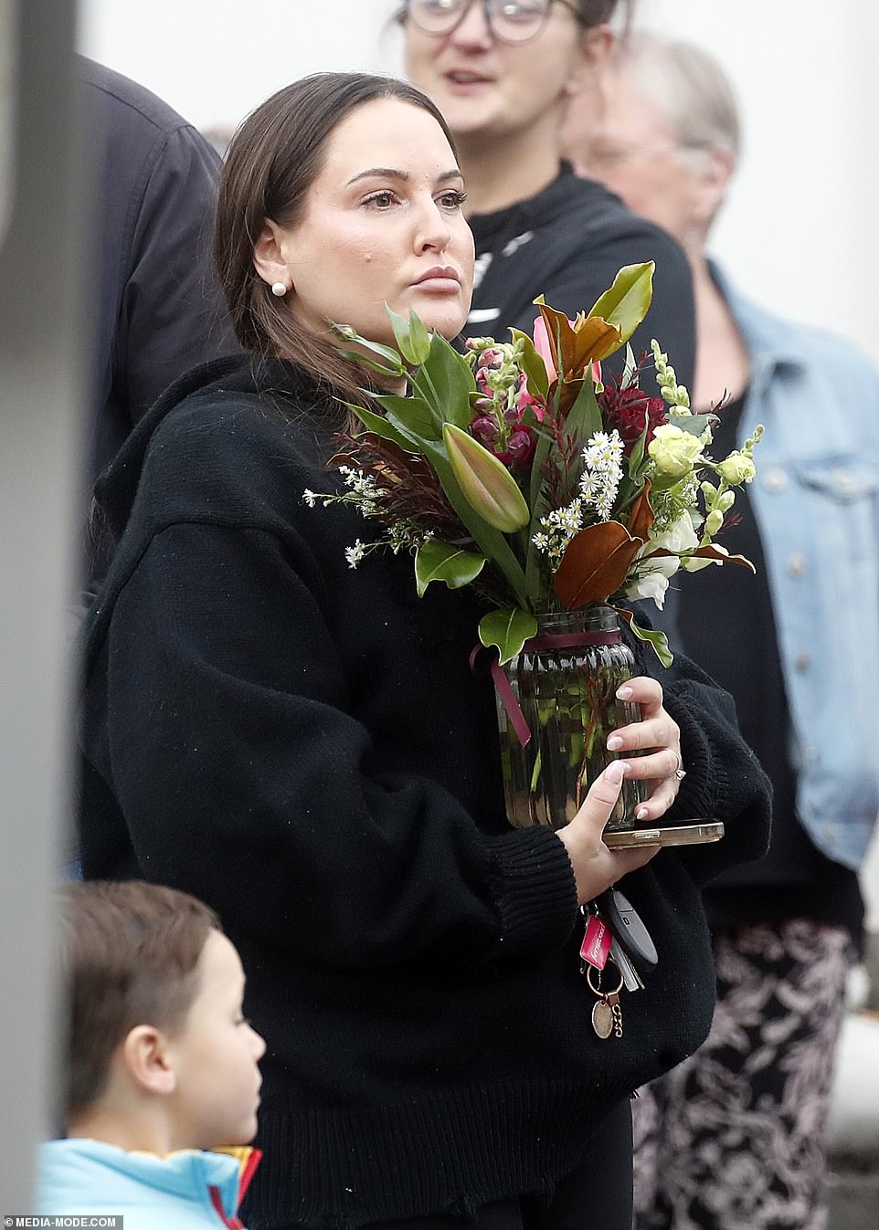 A woman held a vase of flowers at the march in Ballarat on Friday night.