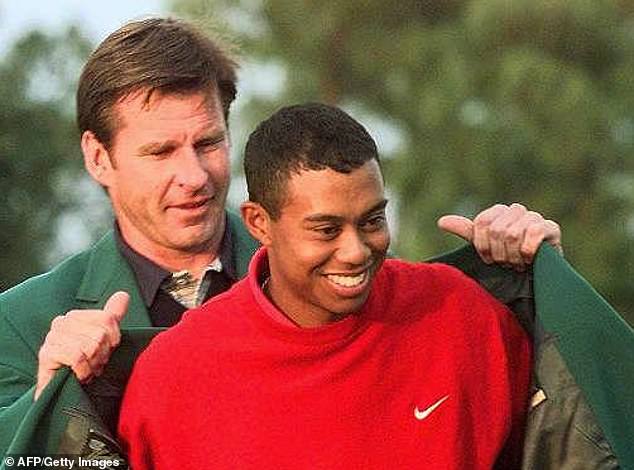 In 1997, Woods won his first major by triumphing at the Masters (pictured with Nick Faldo).