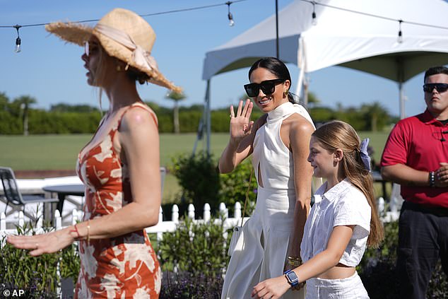 Meghan smiled and waved to the cameras as she walked hand in hand with Alba, Nacho and Delfina's daughter.