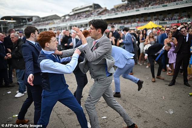 Racing fans battle each other as they brawl on day two of the Grand National Festival horse race at Aintree Racecourse in Liverpool.