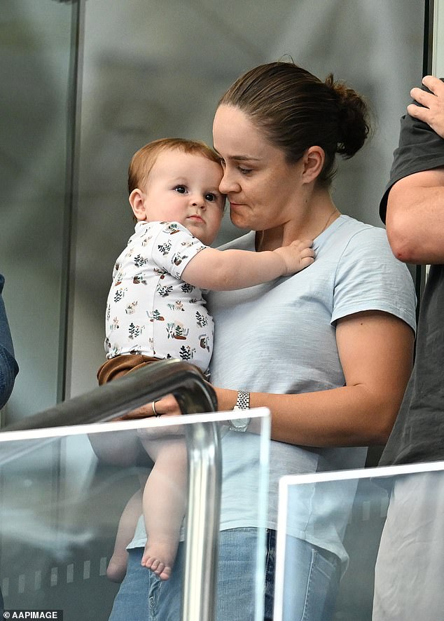 The retired Australian tennis champion, 27, was seen tenderly cradling her baby from the stands as she watched Australia take on Mexico in championship qualifying.