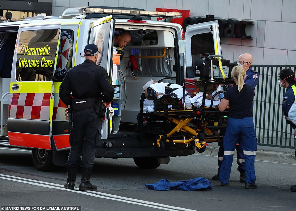 A victim is seen being placed in an ambulance.