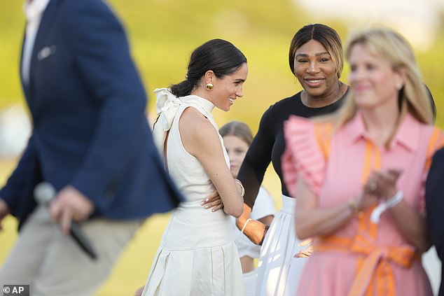The 42-year-old wore a stunning white skirt and black top combo as she hugged Prince Harry, having become close with the couple since they started dating.