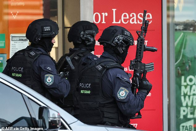 Tactical police appear in the photo with long weapons.