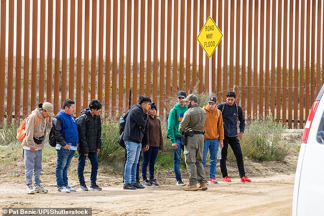 Migrants surrender to U.S. Border Patrol after crossing the border wall from Mexico near Campo, California, about 50 miles from San Diego, on Wednesday, March 13.