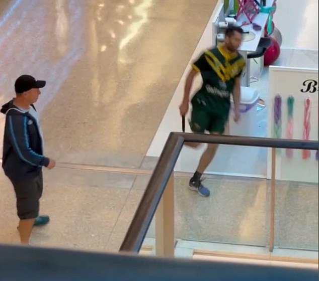 A passer-by armed with a bollard attempts to stop the gunman (pictured) on an escalator at Westfield Bondi.