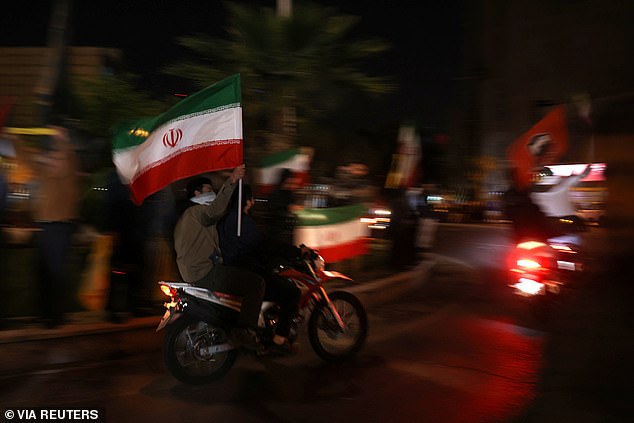 Iranians celebrate in a street, after the IRGC attack on Israel, in Tehran