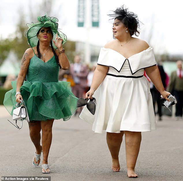 One reveler, dressed in a low-cut white dress, took off her shoes early as she headed to the racecourse.