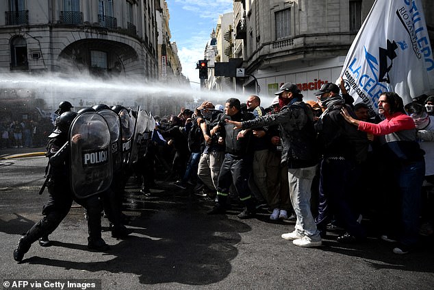 Members of social organizations confront police during a demonstration against the recent economic measures introduced by the government of President Javier Milei in Buenos Aires on Wednesday.  At least two police officers and a media worker were injured and 11 people were arrested.