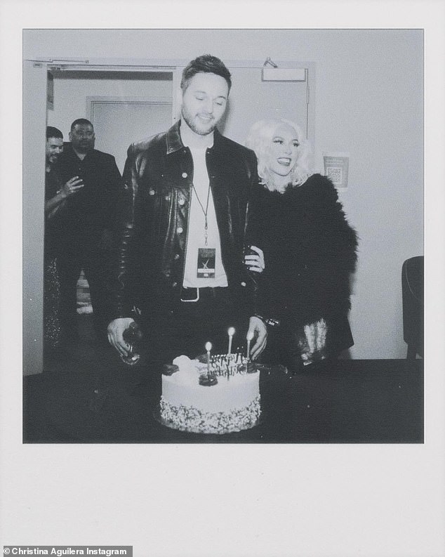 The next slide was a black and white Polaroid snapshot of Xtina and her partner since 2014 admiring their birthday cake.