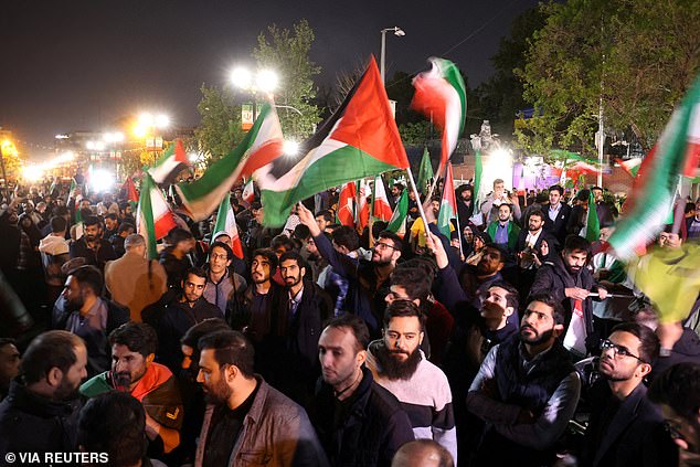 Iranian protesters wave Palestinian flags as they attend an anti-Israel rally outside the British embassy in Tehran, Iran, April 14, 2024.