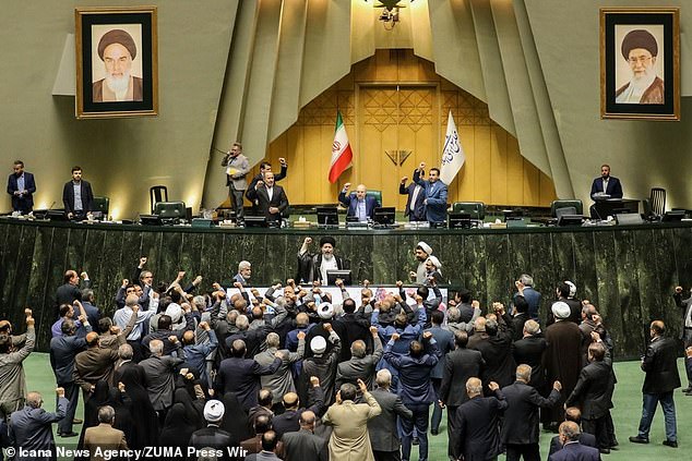 Iranian lawmakers chant slogans at an open session of parliament in Tehran as Iran launches dozens of drones toward Israel.