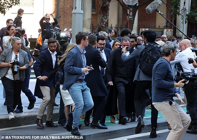 The 28-year-old was flanked by his legal team as he left the NSW Federal Court and made efforts to avoid a crowd of waiting reporters and cameramen (pictured).
