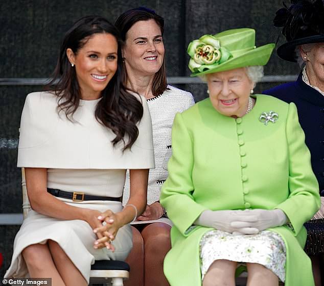 Cohen sitting behind the Queen and Meghan Markle at an event (pictured)