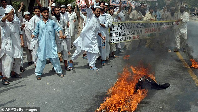 Pakistani activists from Jamiat Tulba Arabia, a student wing of the Jamaat-i-Islami party, shout slogans in front of a burning effigy of Salman Rushdie in Multan on June 17, 2007.