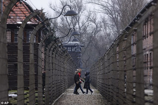 People visit the former Nazi German concentration and extermination camp Auschwitz-Birkenau in Oswiecim, Poland, Thursday, Jan. 26, 2023.